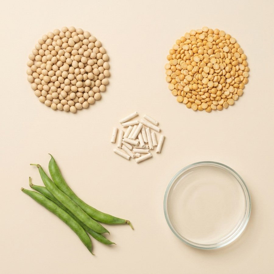 Soybeans, split peas, guar pods and water beside tofu litter pellets